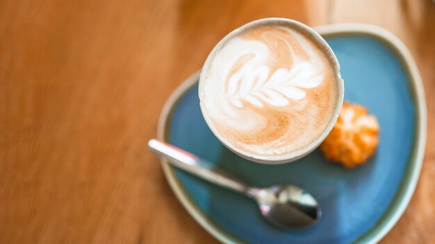 Tasse de café avec belle latte art sur table en bois