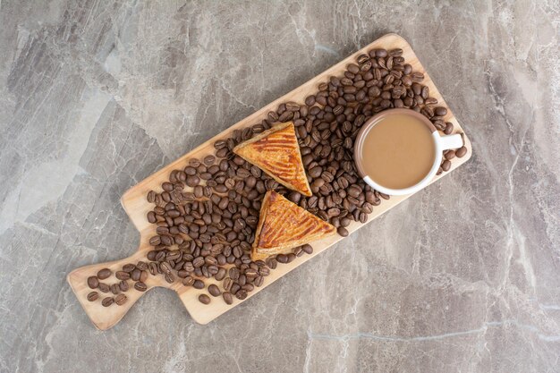 Tasse de café, biscuits et grains de café sur planche de bois. photo de haute qualité