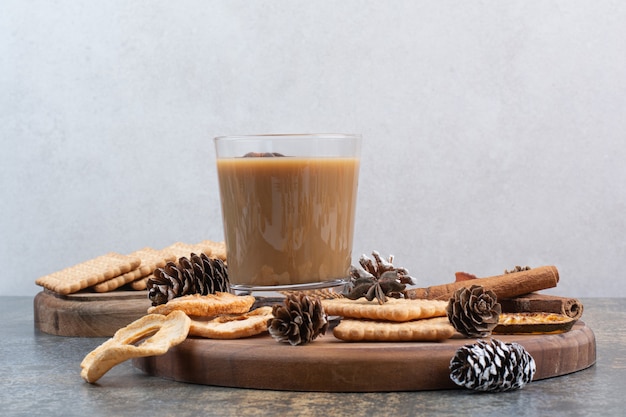 Tasse de café avec des biscuits et des pommes de pin sur une plaque en bois. Photo de haute qualité
