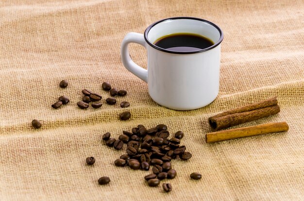 Tasse de café avec cannelle et grains