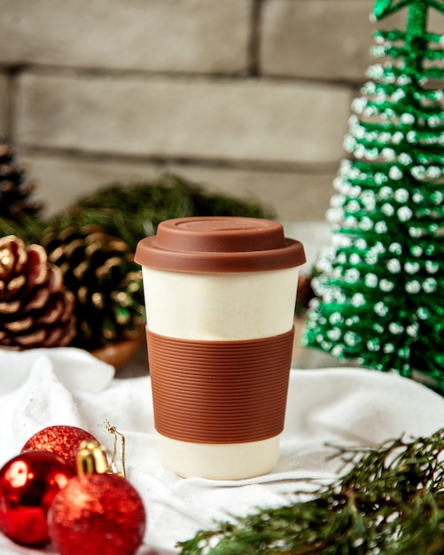 Photo gratuite tasse à café en céramique réutilisable avec couvercle et manchon en silicone marron