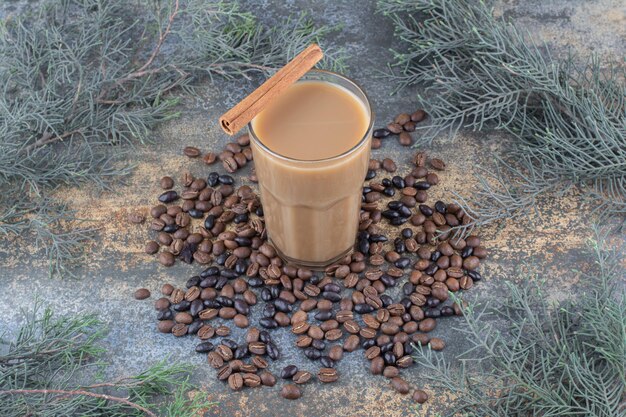 Tasse de café chaud avec bâton de cannelle et grains de café sur fond de marbre. photo de haute qualité