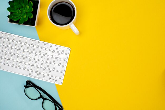 Une tasse de café et un clavier et des lunettes sans fil