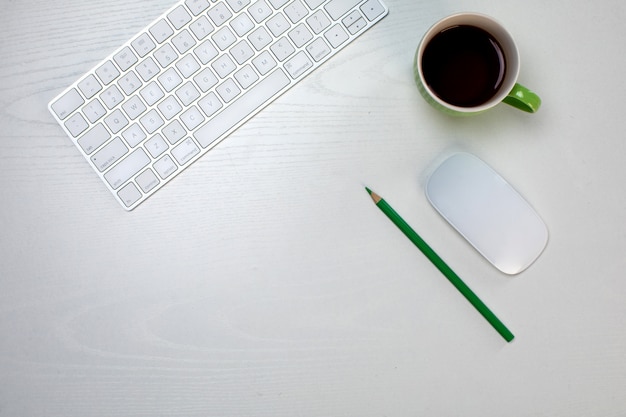 Une tasse de café et un clavier et une souris sans fil