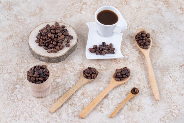 Une tasse de café à côté de plusieurs petits paquets de grains de café