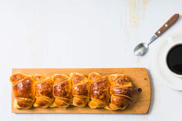 Photo gratuite tasse de café et cuillère près de petits pains