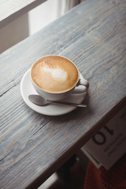 Tasse de café et cuillère sur table en bois