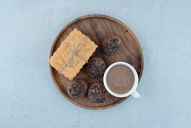 Tasse de café et divers biscuits sur plaque de bois. photo de haute qualité