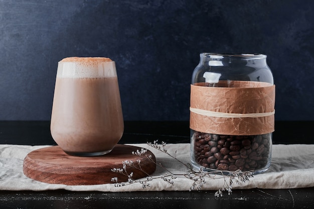 Tasse de café avec du lait et des haricots.