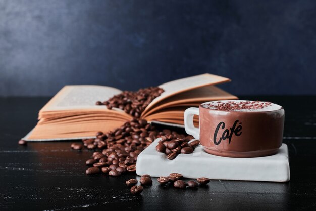 Tasse de café avec des grains autour.