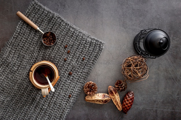 Tasse à café avec des grains de café sur une écharpe grise