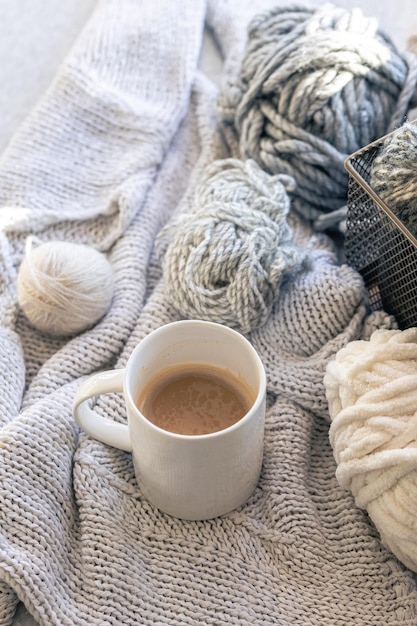 Photo gratuite une tasse de café en gros plan avec des éléments tricotés et des fils de fil