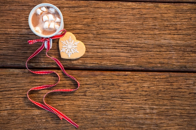 Photo gratuite tasse de café avec des guimauves sur une table en bois et un biscuit