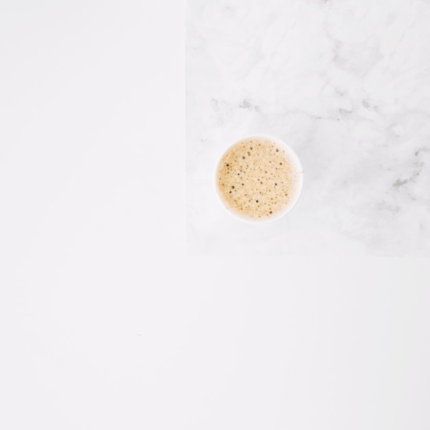 Tasse à café jetable sur napperon sur fond blanc