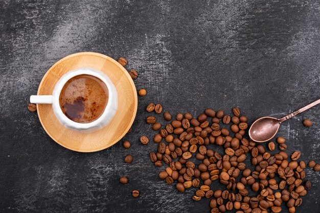 une tasse de café laiteux et mousseux et vue de dessus de grains de café