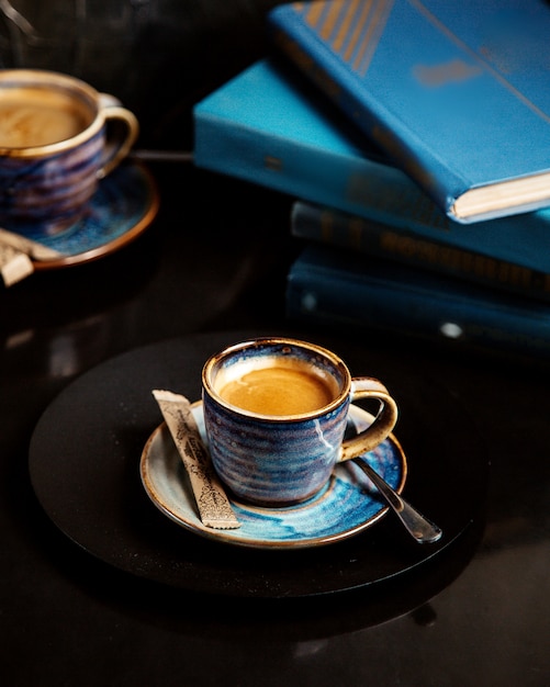 Une tasse de café avec des livres sur la table