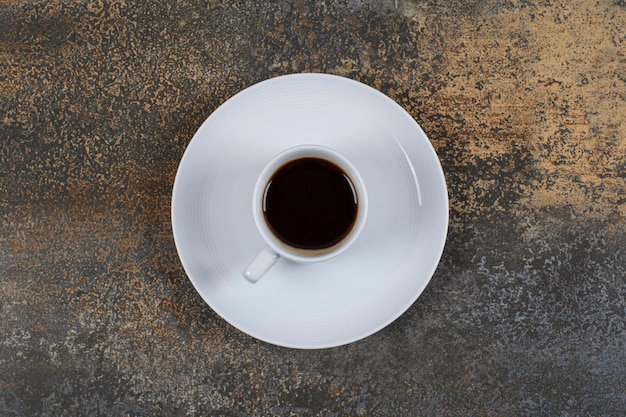 Tasse de café noir sur une surface en marbre.