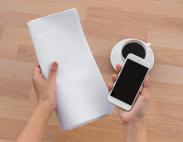 Tasse de café avec un ordinateur portable et une main avec un papier