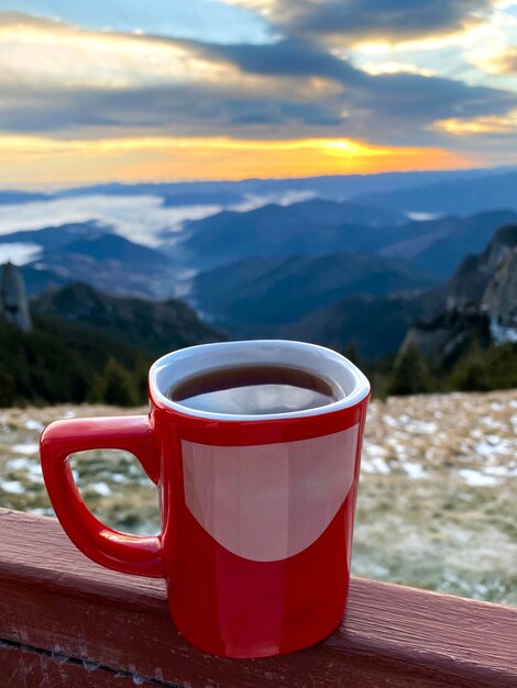 Une tasse de café sur le pic Toaca dans les Carpates au coucher du soleil Roumanie