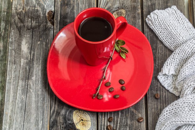 Tasse à café rouge sur une assiette beau mur en bois