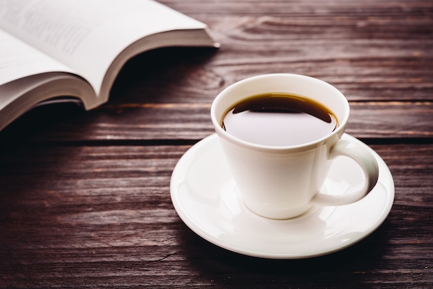 Tasse de café sur une table en bois et un livre