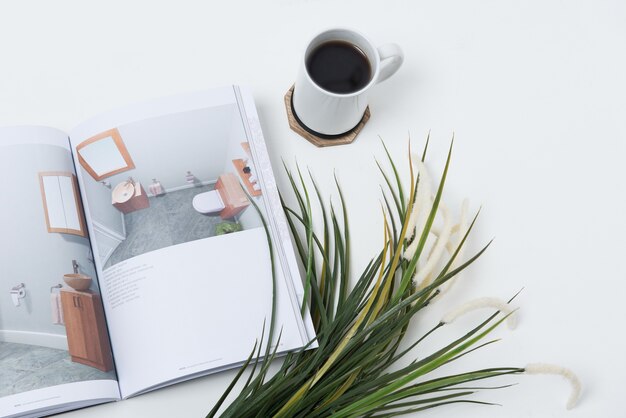 Tasse de café sur la table près d'un journal et de plantes