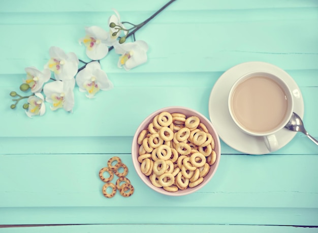 Photo gratuite tasse de café sur la vieille vue de dessus de table en bois avec des fleurs fraîches printanières avec une grande assiette de bubliks russes