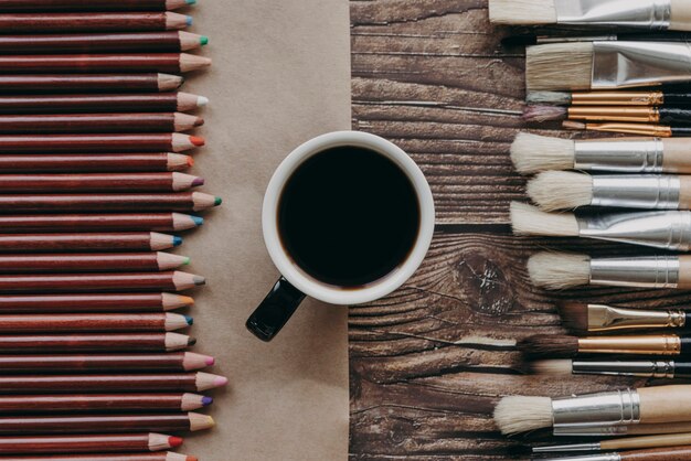 Tasse à café vue de dessus, pinceaux et crayons