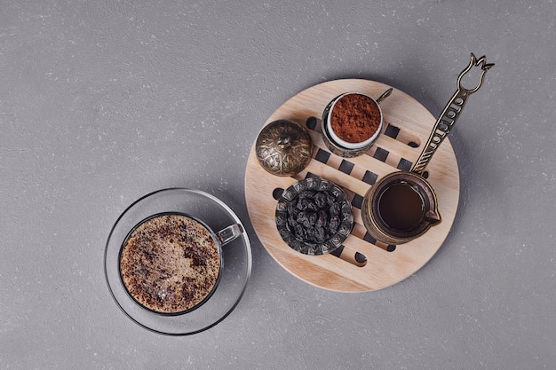 Une tasse de cappuccino avec de la cannelle en poudre autour.