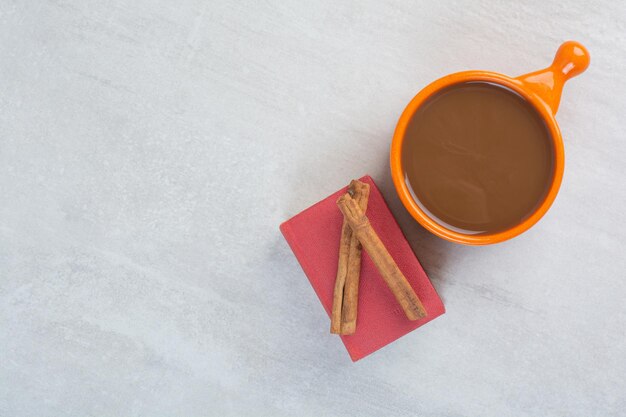 Tasse de chocolat chaud, livre et cannelle sur fond gris. photo de haute qualité