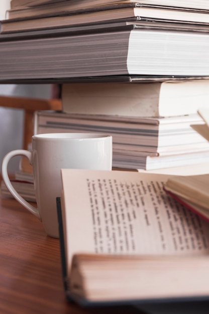 Photo gratuite tasse debout près des livres