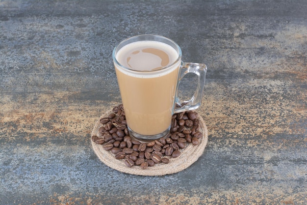 Une tasse de délicieux café avec des grains de café sur fond de marbre. photo de haute qualité