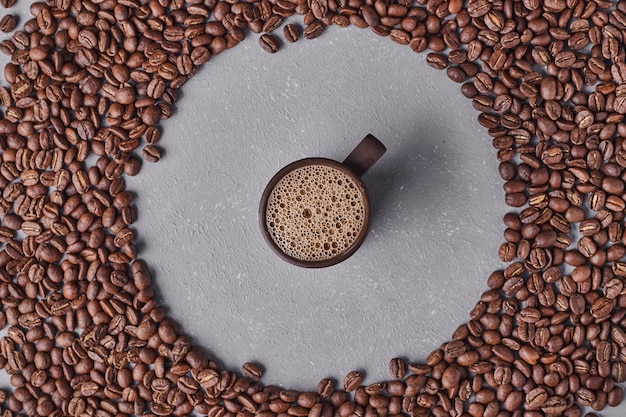 Une tasse d'espresso au milieu de grains de café.