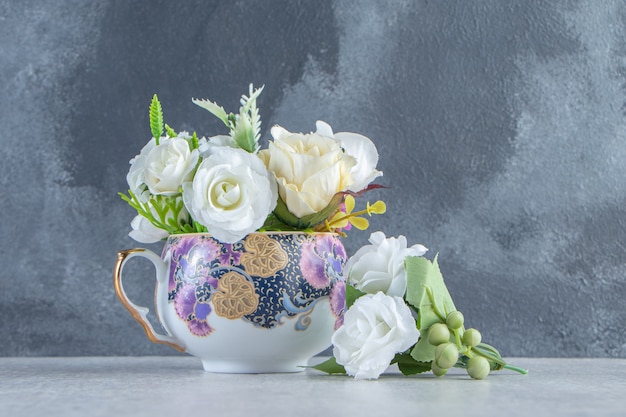 Une tasse de fleurs blanches fraîches , sur fond blanc.