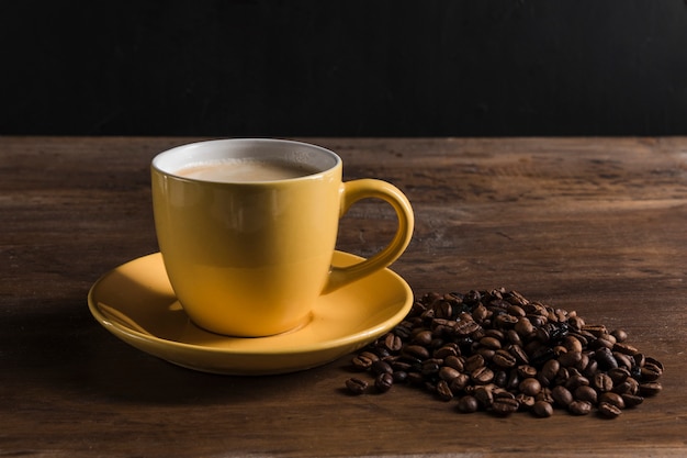 Tasse jaune et grains de café
