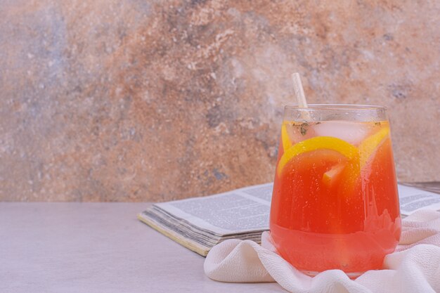 Une tasse de jus avec des tranches de fruits dedans