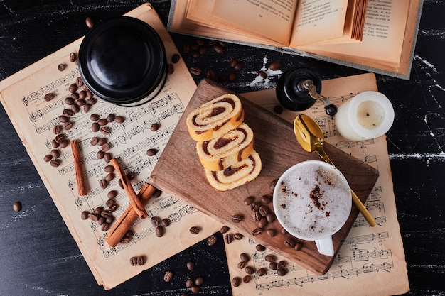 Tasse de lait avec café en poudre et rollcake.