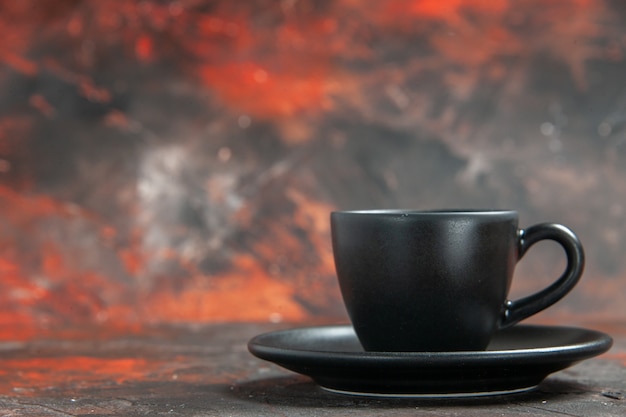 Photo gratuite tasse et soucoupe noires vue de face sur une table rouge foncé