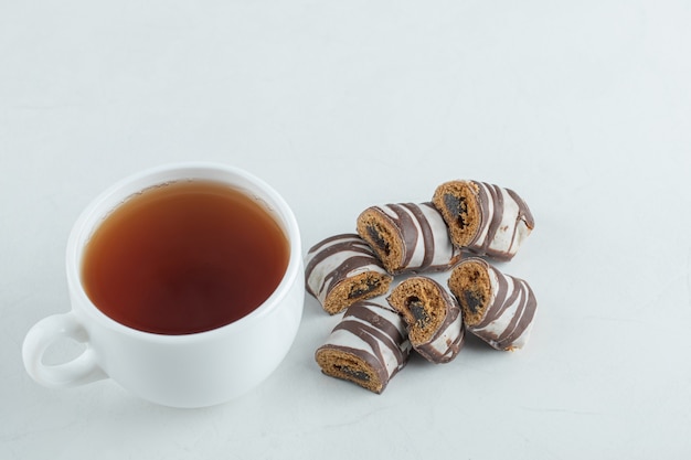 Une tasse de thé aromatique avec des barres de chocolat.