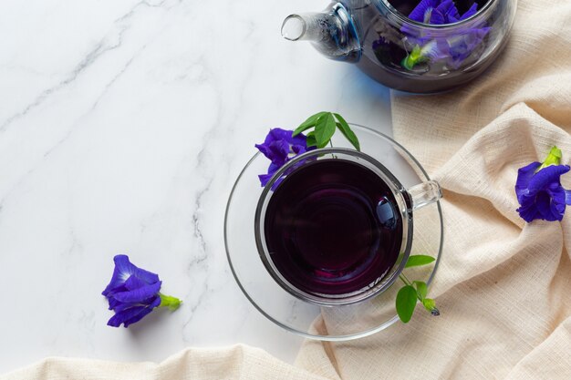 Tasse de thé aux fleurs de pois papillon avec du miel sur la table