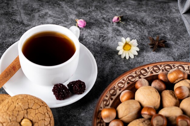 Une tasse de thé avec des baies et des noix