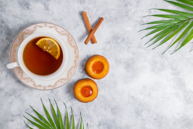 Une tasse de thé avec des biscuits à la confiture d'abricots faits maison.