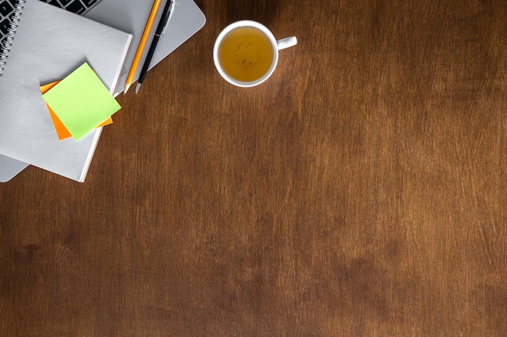 Photo gratuit une tasse de thé et un bloc-notes sur une table en bois