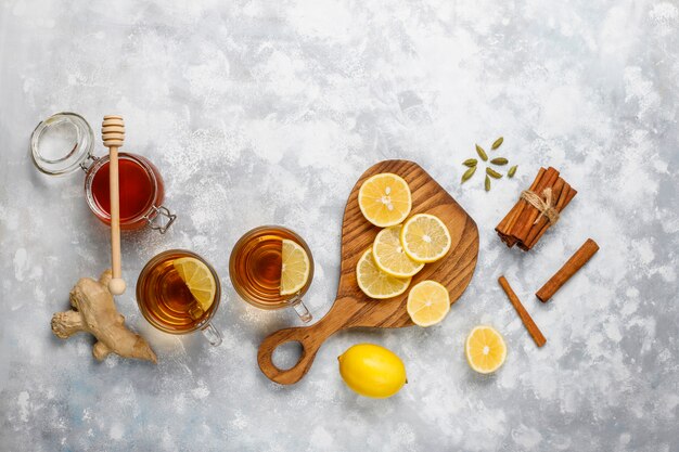 Une tasse de thé, de cassonade, de miel et de citron sur du béton. Vue de dessus, espace de copie