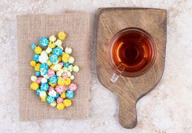 Une tasse de thé chaud avec des bonbons colorés