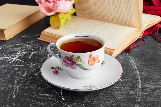 Une tasse de thé dans une soucoupe décorative.