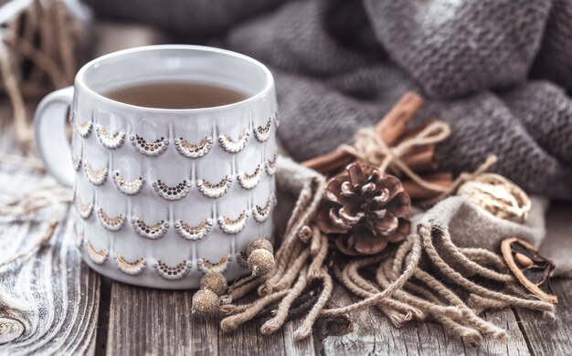 une tasse de thé douillette sur un fond en bois, un concept de chaleur et de décoration