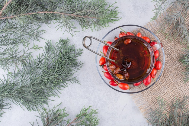 Photo gratuite tasse de thé avec des églantiers frais sur une table en marbre. photo de haute qualité