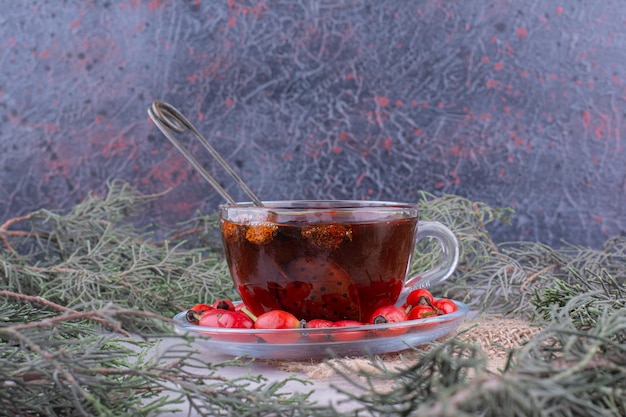 Photo gratuite tasse de thé avec des églantiers frais sur une table en marbre. photo de haute qualité