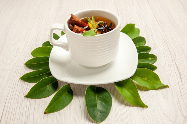 Photo gratuite tasse de thé avec des feuilles vertes sur blanc